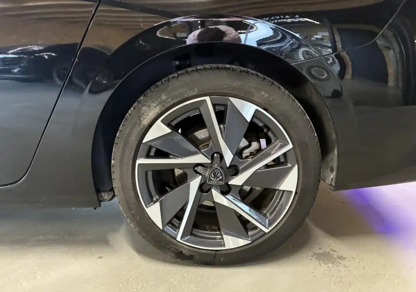 Gros plan sur la roue arrière droite de la Peugeot 308 SW noire 2024 avec jante alliage 17'' Halong diamantée.