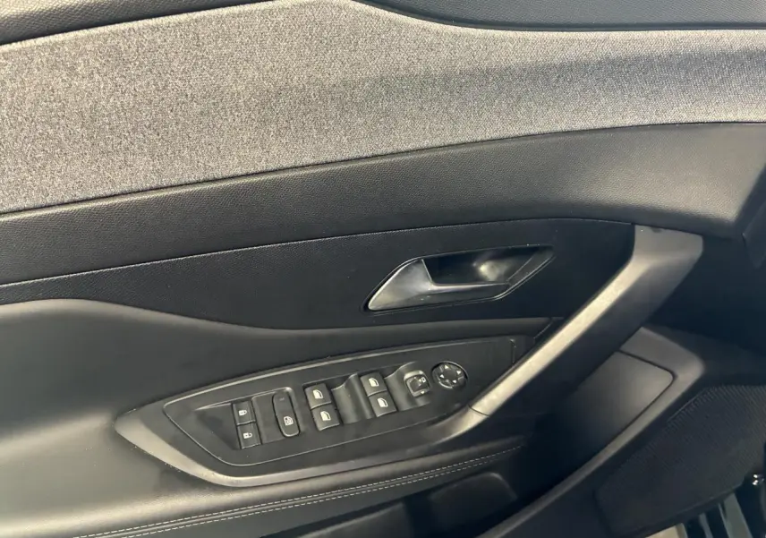 Gros plan sur la porte côté gauche de la Peugeot 308 SW noire, avec commandes des vitres et poignée intégrée.