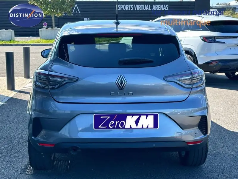 Vue arrière d'une Renault Clio gris Rafale 2025 avec feux LED et becquet arrière visible en plein jour.