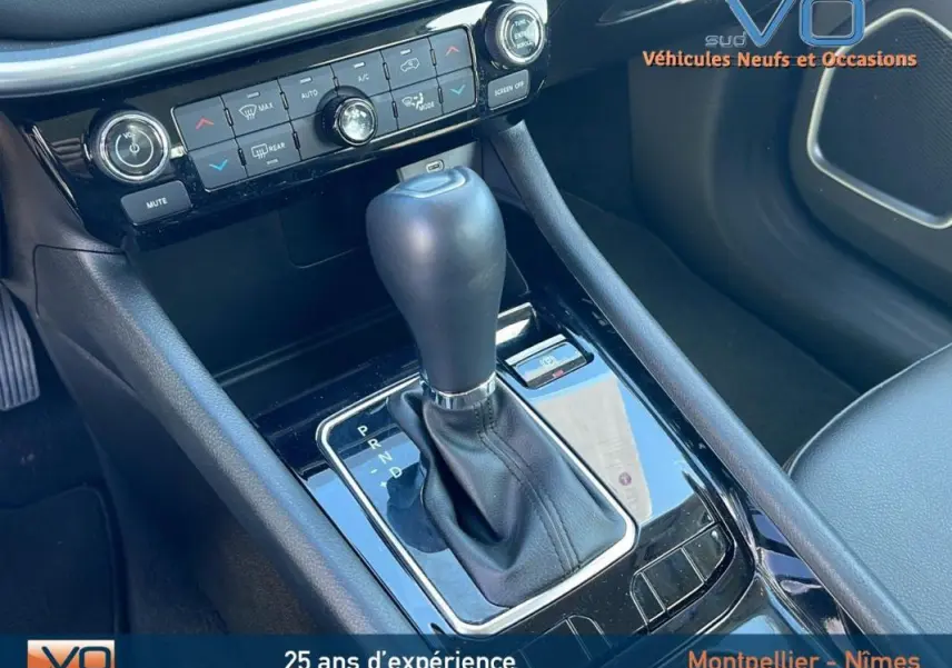 Gros plan sur la console centrale du Jeep Compass 2024 avec levier de boîte auto et commandes climatisation.