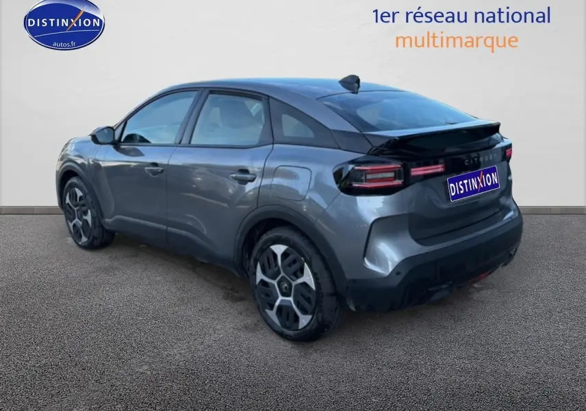 Vue 3/4 arrière droite d'une Citroën C4 électrique gris foncé avec feux arrière LED et jantes distinctives.