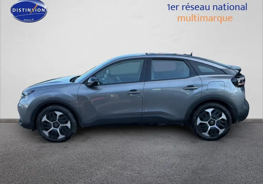 Profil côté gauche d'une Citroën C4 électrique 2025 gris foncé avec jantes distinctives et lignes fluides.