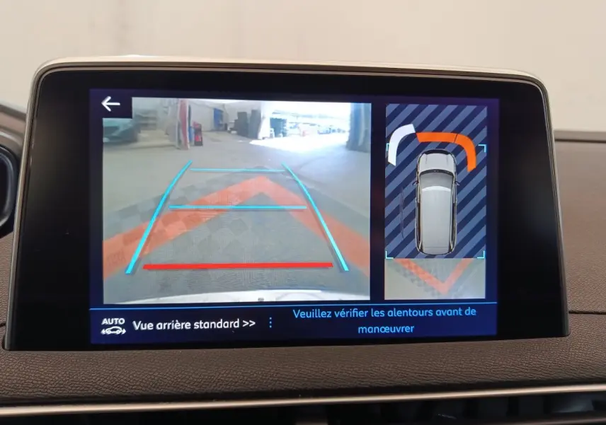 Écran tactile affichant la caméra de recul et l’aide au stationnement du Peugeot 5008 gris clair, vue intérieure.