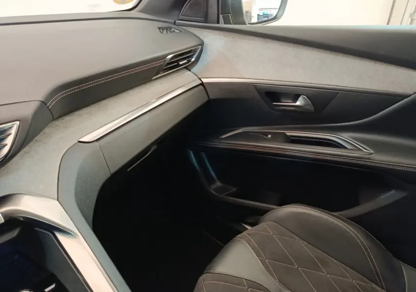 Vue intérieure côté passager du Peugeot 5008 GT 2019, avec tableau de bord gris clair et sellerie cuir noire.