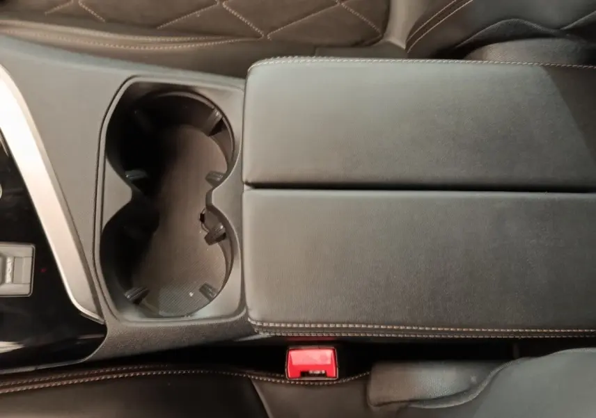Gros plan sur la console centrale noire avec porte-gobelets et accoudoir en cuir du Peugeot 5008 gris clair 2019.