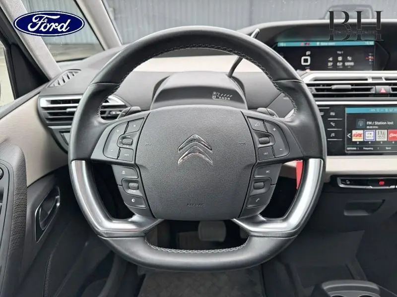 Vue rapprochée du volant cuir multifonction noir et argenté d'un Citroën C4 Spacetourer avec tableau de bord numérique.
