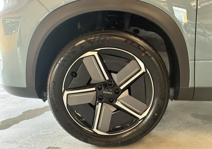 Gros plan sur la roue avant gauche du SUV JAECOO J7 2026 en gris olive, avec jante alliage noire et grise design moderne.