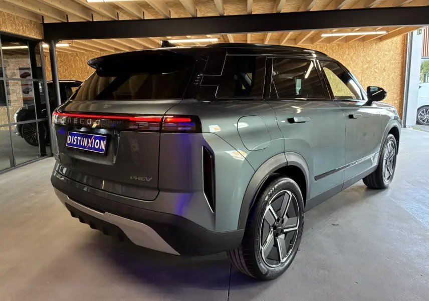 Vue 3/4 arrière droite du SUV JAECOO J7 gris olive avec toit noir et feux arrière LED continus en intérieur.