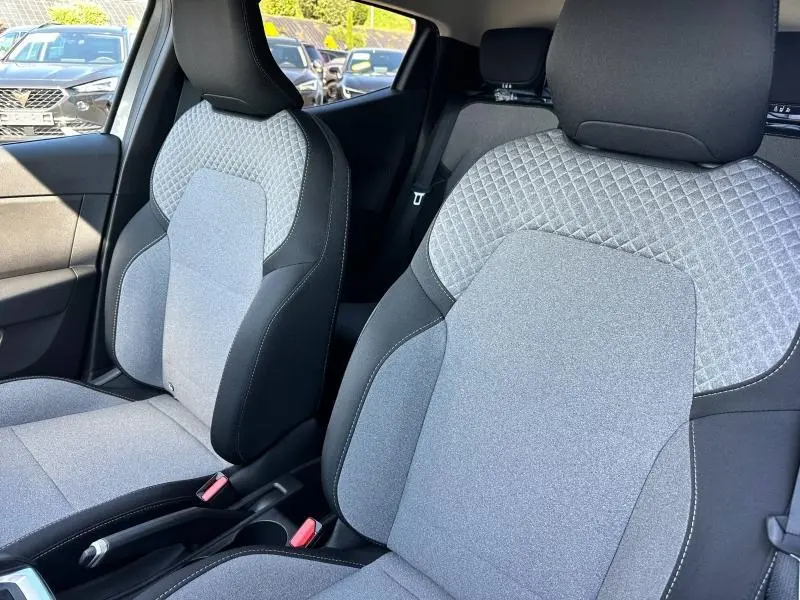 Vue intérieure rapprochée des sièges avant gris clair avec motif 3D et contours noirs de la Renault Clio 2025.