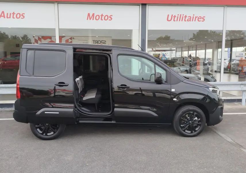 Profil côté droit du Citroën Berlingo noir Perla Nera avec porte coulissante ouverte, montrant l'intérieur des sièges.