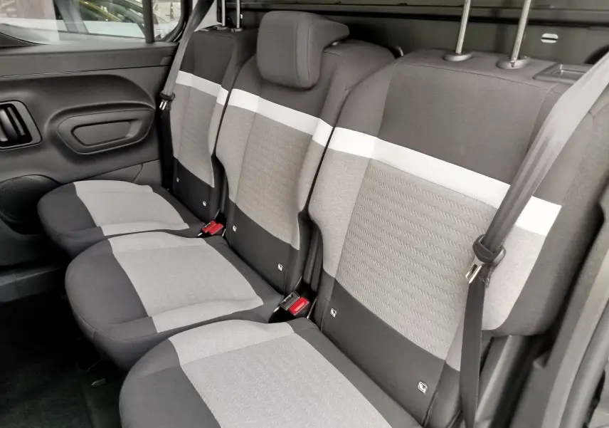 Vue latérale intérieure des sièges arrière gris clair et foncé du Citroën Berlingo 2025, version Plus+Pack Style.