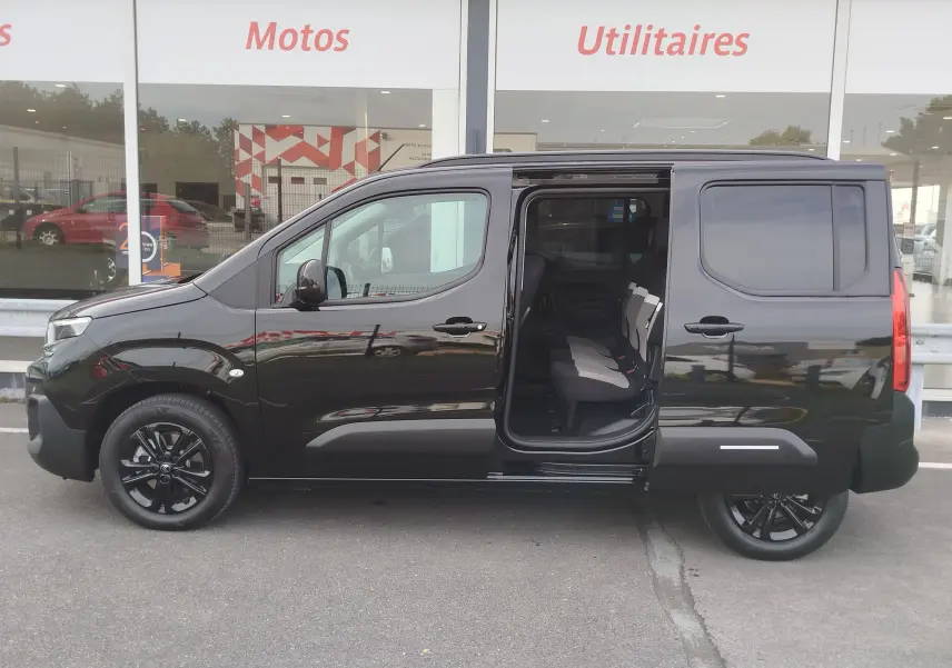 Profil côté gauche du Citroën Berlingo noir Perla Nera 2025 avec porte coulissante ouverte révélant les sièges arrière.