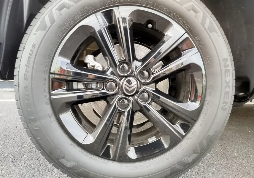 Gros plan sur la roue avant droite du Citroën Berlingo noir Perla Nera avec jante alliage brillante et pneu Nexen.