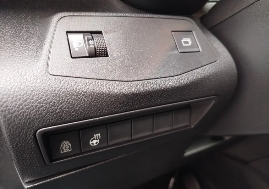 Détail des commandes noires sur le tableau de bord du Citroën Berlingo 2025, version diesel noire.