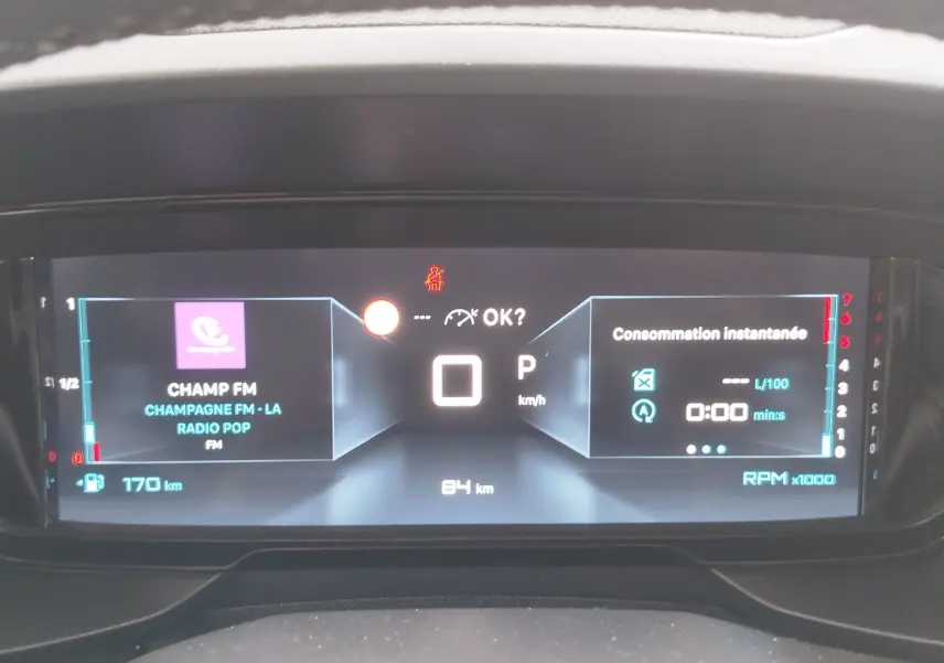 Tableau de bord numérique du Citroën Berlingo 2025 affichant vitesse, radio et consommation instantanée.