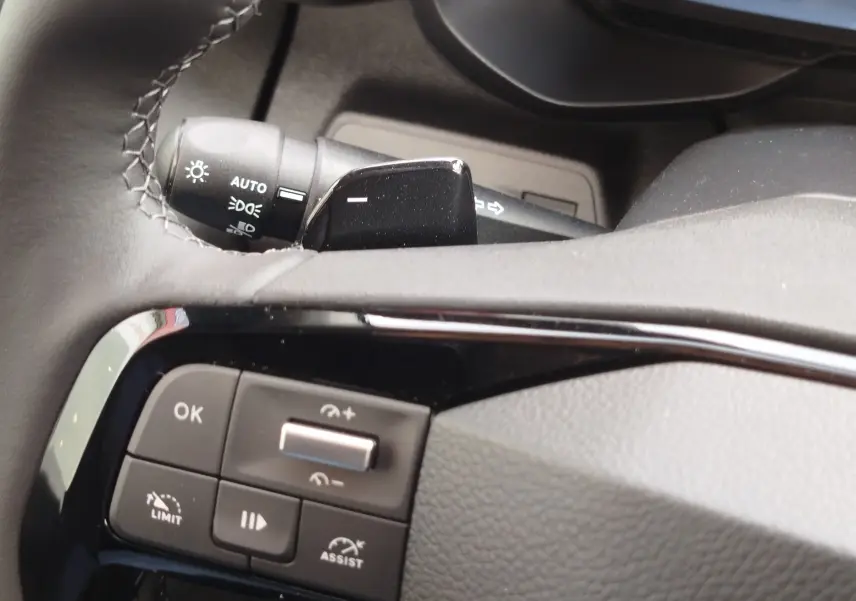 Gros plan sur les commandes au volant côté gauche du Citroën Berlingo noir Perla Nera, avec régulateur de vitesse et limiteur.