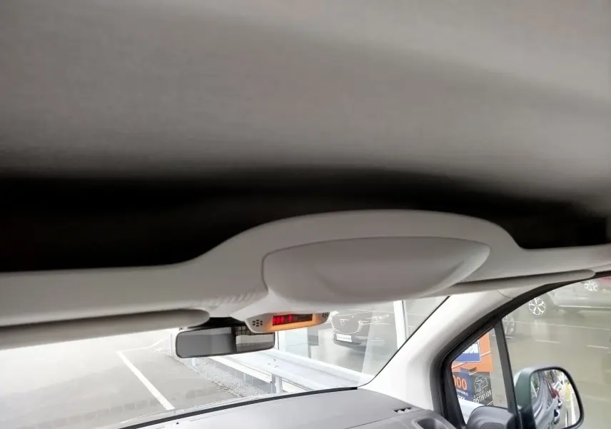 Vue intérieure du toit et pare-brise du Citroën Berlingo noir Perla Nera, avec rétroviseur et capteur de lumière visible.