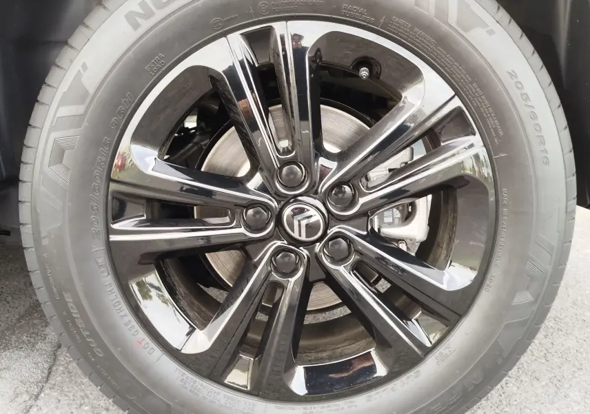 Gros plan sur la jante noire brillante et le pneu Nexen 205/60 R16 du Citroën Berlingo noir Perla Nera Metal 2025.