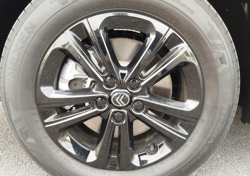 Gros plan sur la jante noire brillante du Citroën Berlingo 2025, soulignant le logo central et le pneu Nexen.