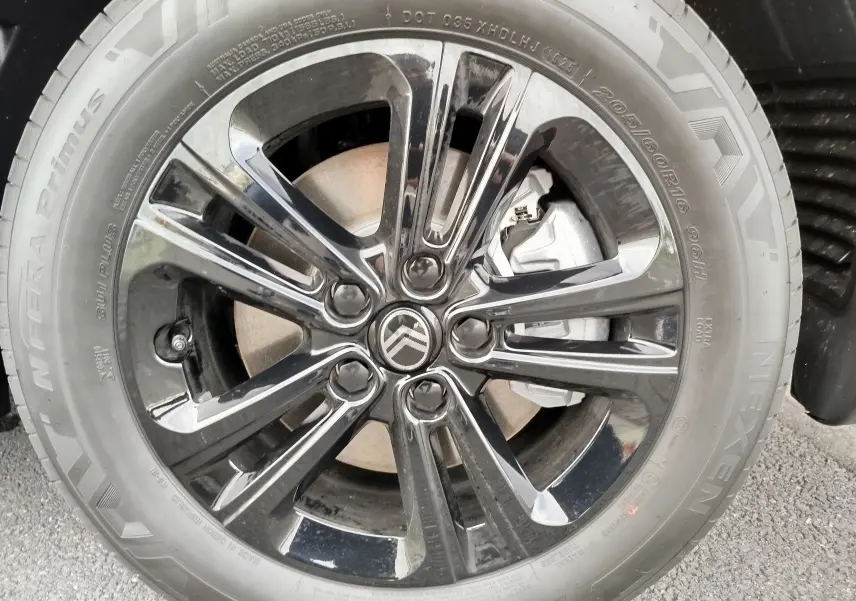 Gros plan sur la jante noire brillante et le logo Citroën d'un Citroën Berlingo noir Perla Nera 2025.