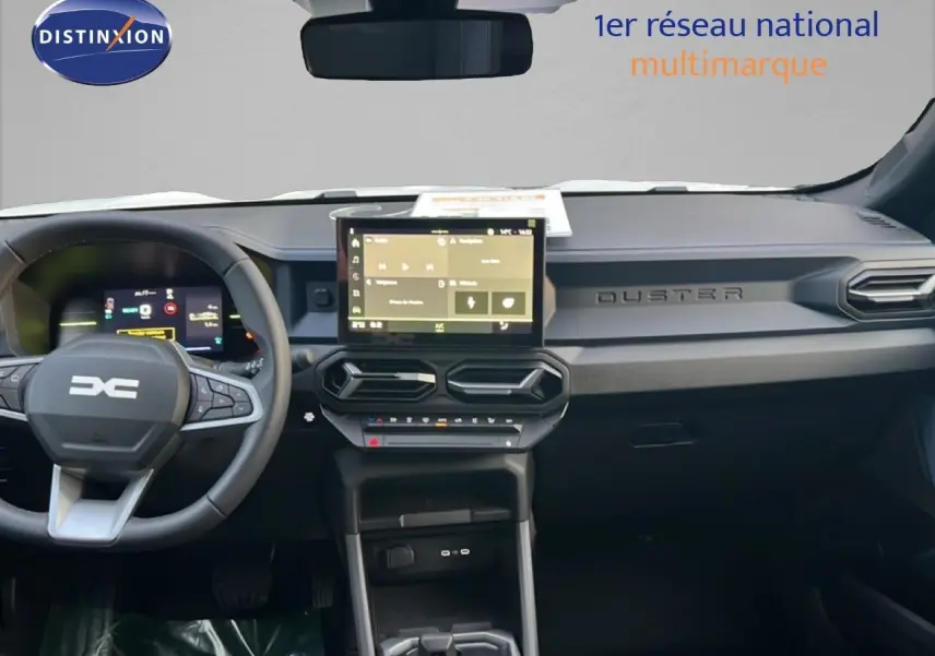 Vue intérieure du tableau de bord du Dacia Duster blanc glacier 2025, avec écran tactile central et volant multifonction.