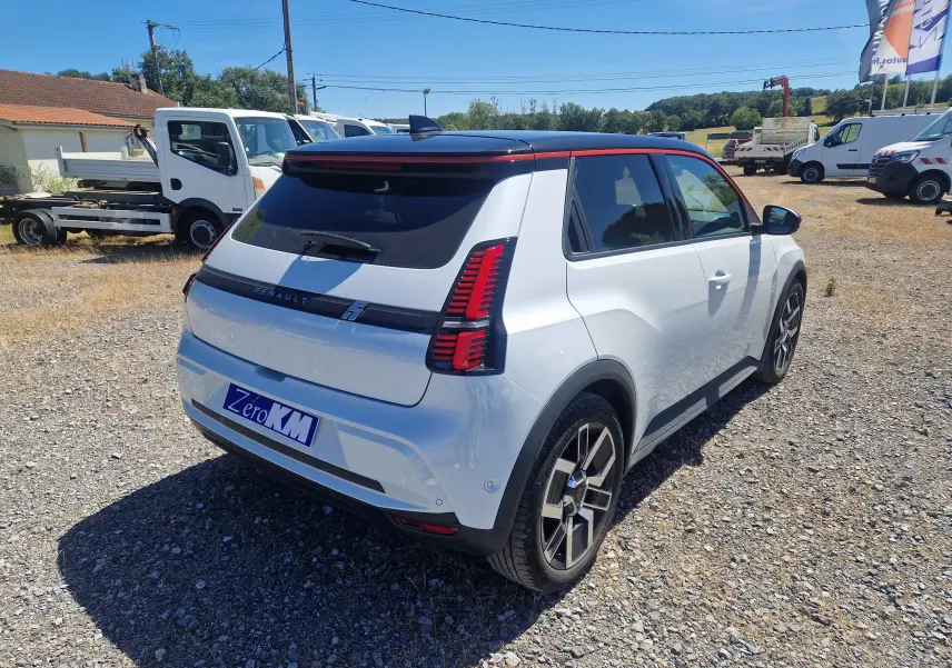 Vue 3/4 arrière droite d'une Renault R5 E-TECH blanc nacré et noir avec feux arrière verticaux distinctifs.