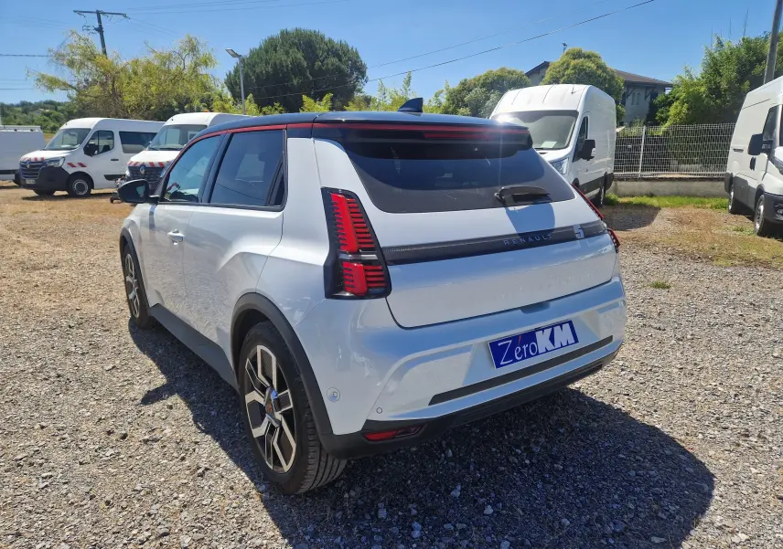 Vue 3/4 arrière droite de la Renault R5 E-TECH 2025 blanc nacré avec toit noir et feux arrière LED distinctifs.