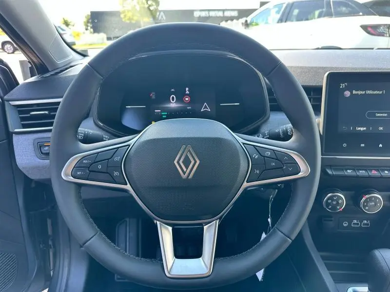 Vue frontale du volant multifonction noir de la Renault Clio 2025 avec tableau de bord numérique et écran tactile central.