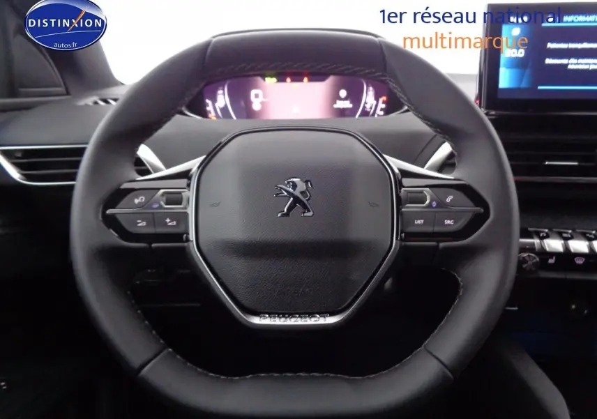 Volant Peugeot 3008 2023 en cuir noir avec commandes intégrées, tableau de bord numérique et écran central visible en arrière-plan.