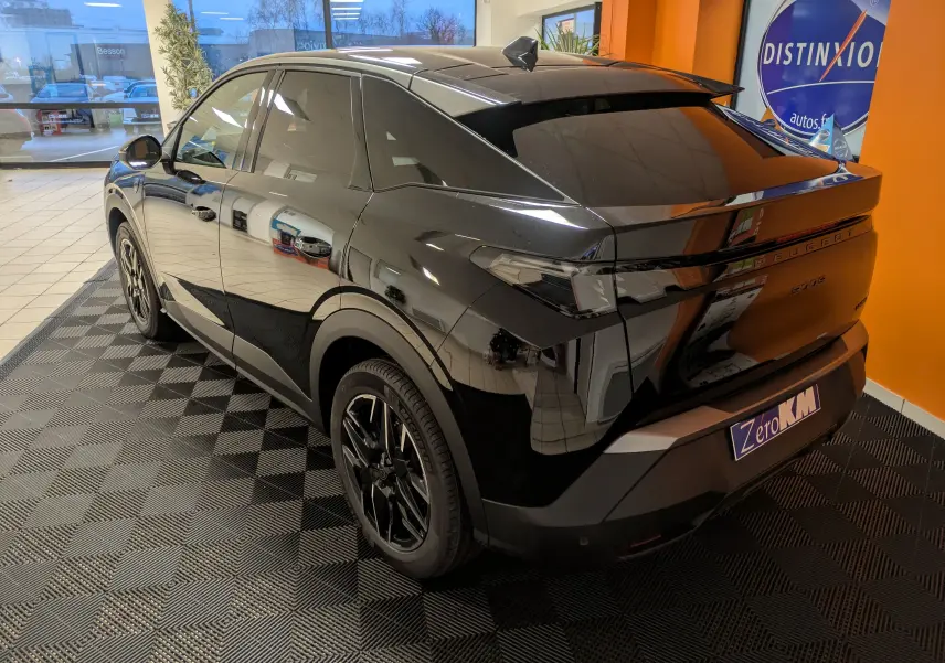 Vue 3/4 arrière droite du Peugeot 3008 Hybrid noir, avec vitres surteintées et jantes alliage 19 pouces en showroom.
