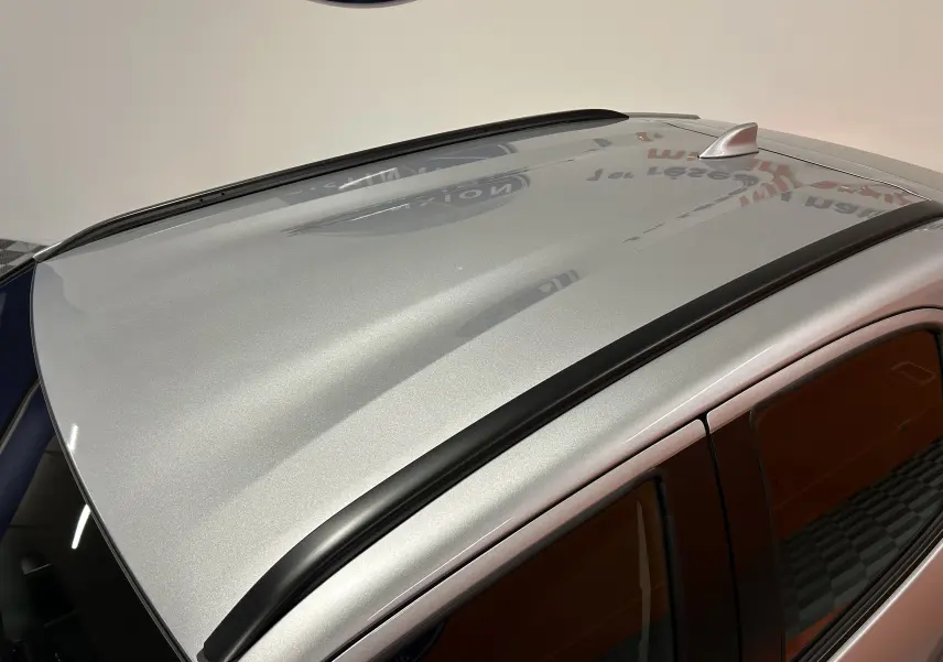 Toit gris minéral de Toyota Yaris Cross 2025 vu en plongée, avec barres de toit noires et antenne requin.