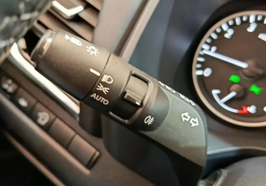 Gros plan sur la manette de clignotants et phares du tableau de bord du Nissan Qashqai gris foncé, 2022.
