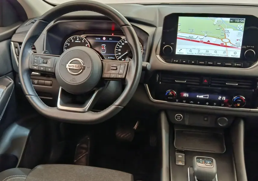 Vue intérieure du tableau de bord du Nissan Qashqai 2022, avec volant cuir, écran tactile et navigation affichée.