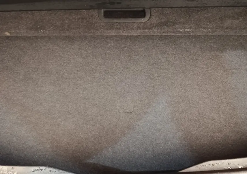 Vue intérieure du coffre spacieux du Nissan Qashqai 1.3 MHEV gris foncé, avec revêtement en tissu gris.