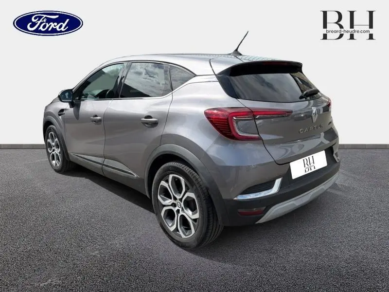 Vue 3/4 arrière droite d'un Renault Captur 2022 gris Cassiopée avec jantes alu et feux arrière LED.
