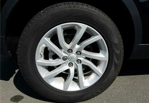 Gros plan sur la roue avant droite du Land Rover Discovery Sport noir de 2017, avec jante en alliage argentée à plusieurs branches.