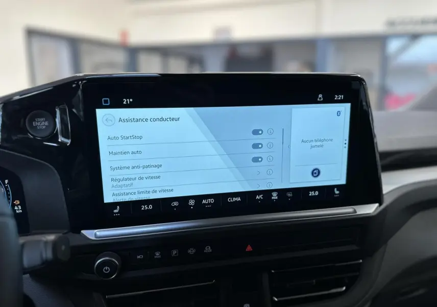 Vue rapprochée de l'écran tactile central du Volkswagen Transporter T7 noir, affichant les options d'assistance conducteur.