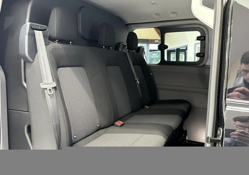 Vue intérieure côté droit du Volkswagen Transporter T7 ProCab 2026 noir Minuit, montrant la banquette arrière en tissu à rayures.