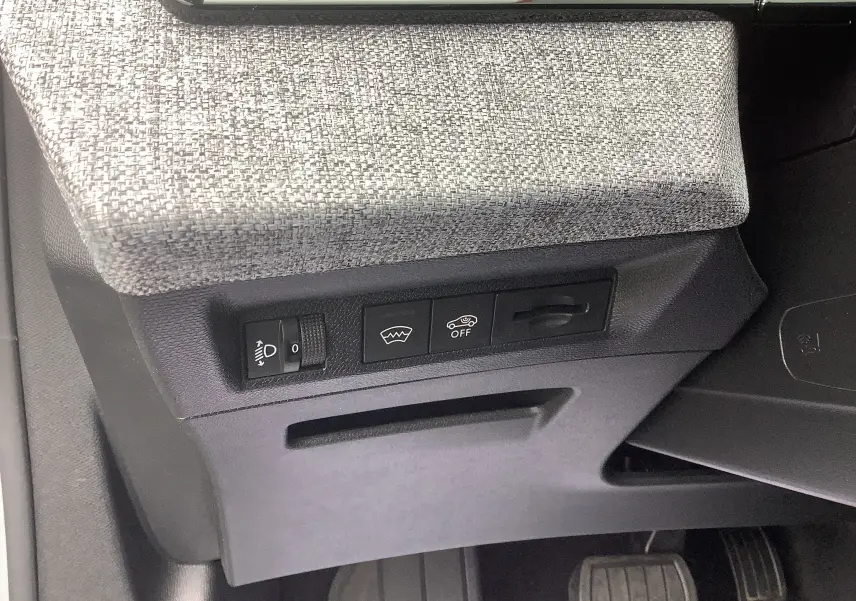 Détail des commandes sous le tableau de bord côté gauche du Peugeot 3008 blanc Okenite hybride 2024.
