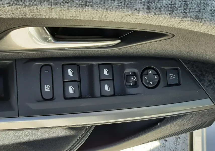 Gros plan sur la commande des vitres et rétroviseurs côté conducteur d’un Peugeot 3008 blanc Okenite 2024.