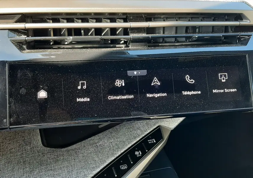 Vue rapprochée de la console centrale du Peugeot 3008 Hybrid 2024, écran tactile avec options multimédia et climatisation.