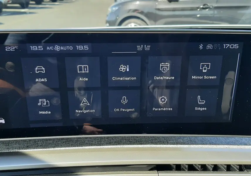 Vue intérieure du tableau de bord du Peugeot 3008 Hybrid 2024, écran tactile central avec menu des fonctions et bouton start/stop.
