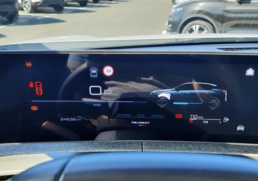 Vue intérieure du tableau de bord numérique du Peugeot 3008 Hybrid blanc, affichant l'autonomie et la vitesse.