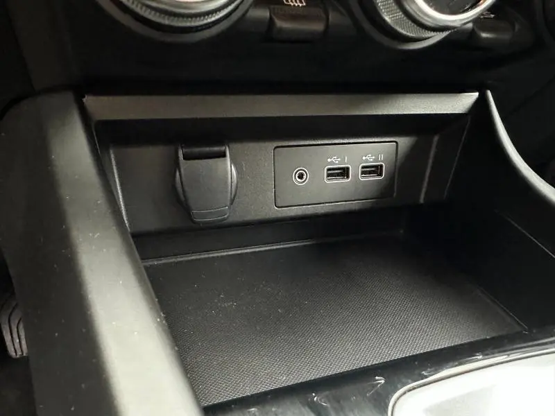 Gros plan sur la console centrale du Renault Arkana 2025 montrant deux ports USB et une prise auxiliaire.