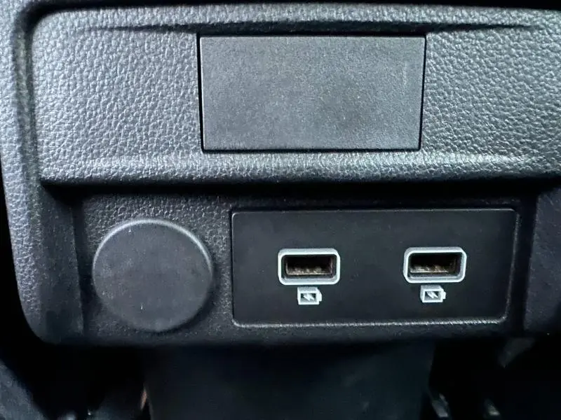 Gros plan sur deux ports USB et une prise 12V dans l’habitacle noir du Renault Arkana 2025.