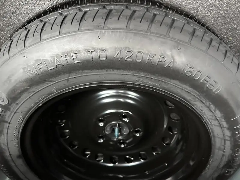 Gros plan sur la roue de secours noire du Renault Arkana 2025, mettant en valeur le pneu avec inscription de pression.