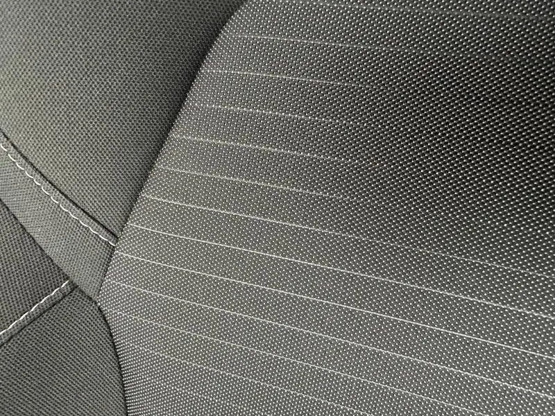 Détail du tissu gris foncé avec surpiqûres blanches des sièges du Renault Arkana 2025.