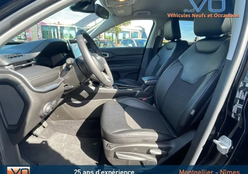 Intérieur avant du Jeep Compass noir 2023, vue côté conducteur montrant sièges cuir et tableau de bord moderne.