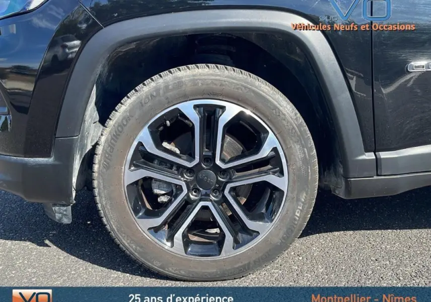 Gros plan sur la roue avant gauche du Jeep Compass noir 2023 avec jante 18 pouces au design moderne.