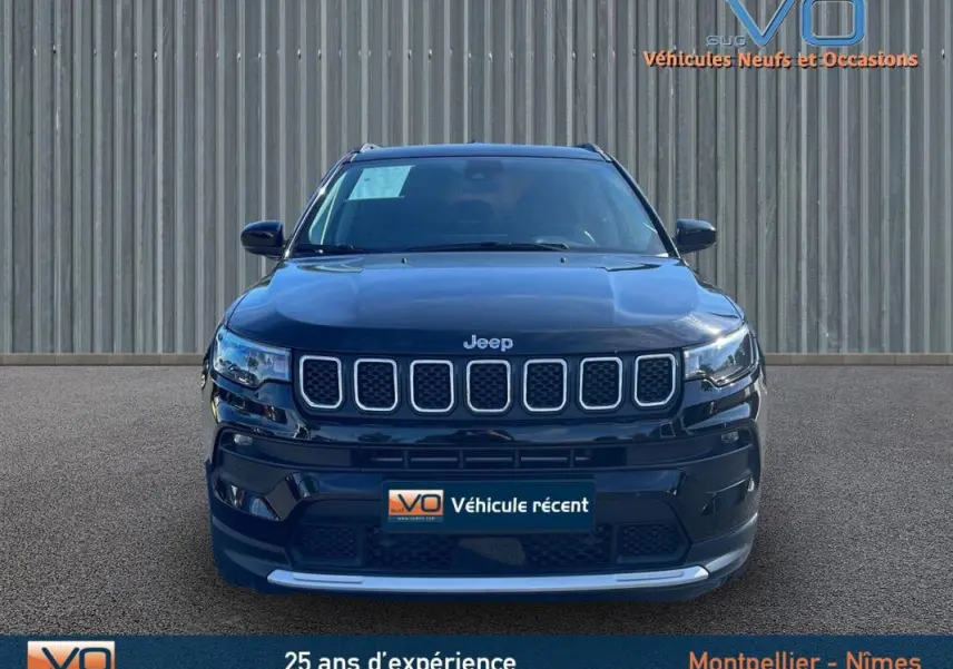 Vue frontale d'un Jeep Compass noir 2023 avec calandre distinctive et barres de toit visibles sur fond neutre.